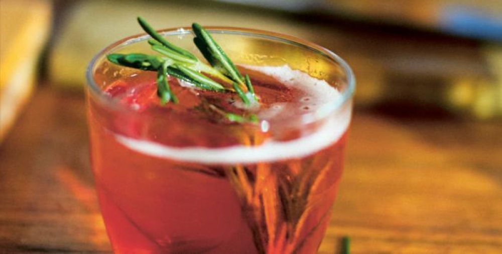 A red cocktail with sprigs of mint