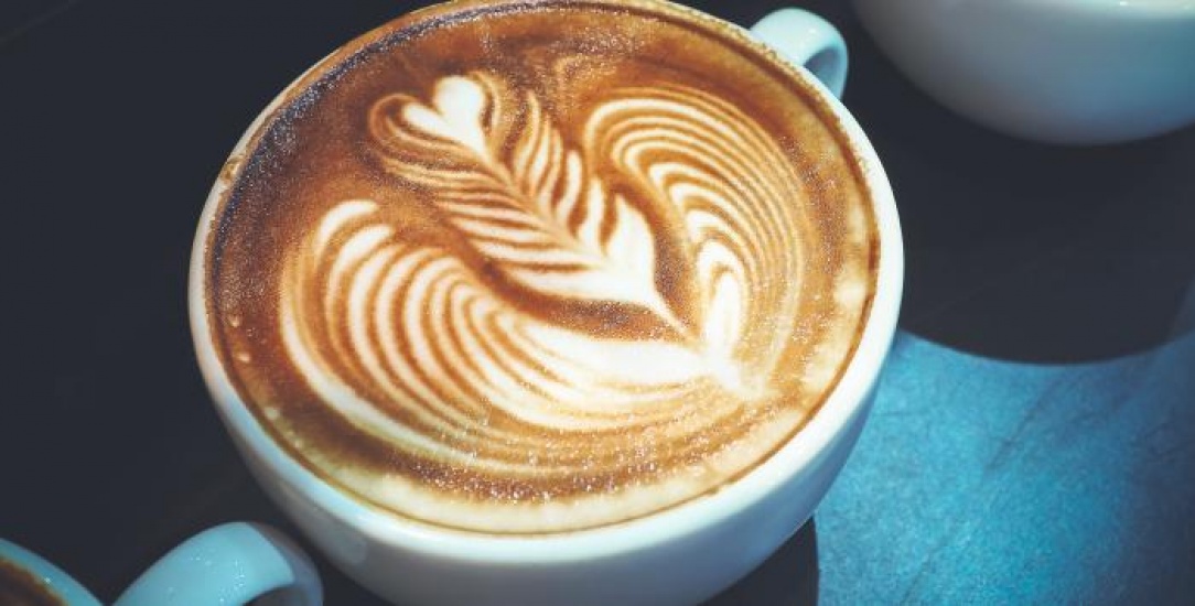 Latte coffee with heart shaped swirls in milk foam