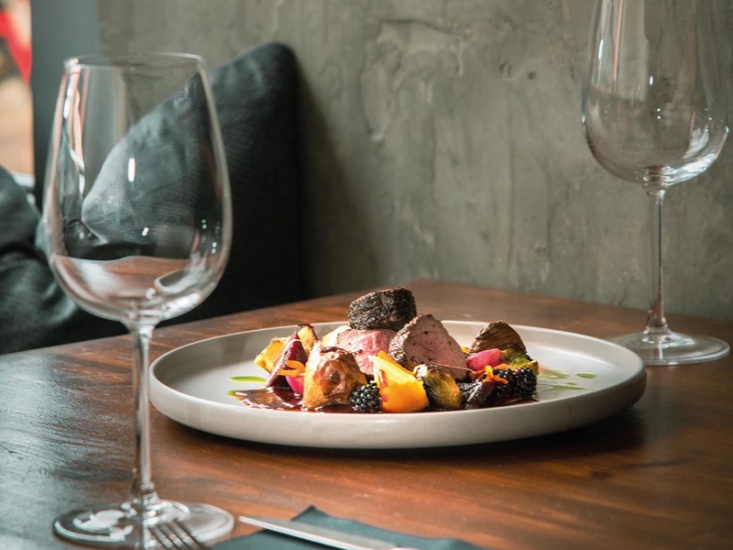 plate on food sat on table with wine glasses