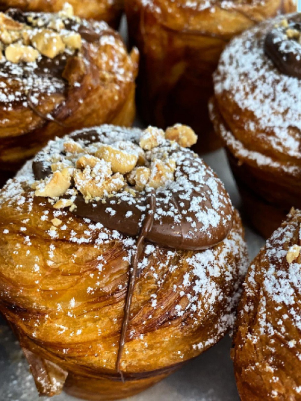 pastries topped with chocolates and nuts, dusted with icing