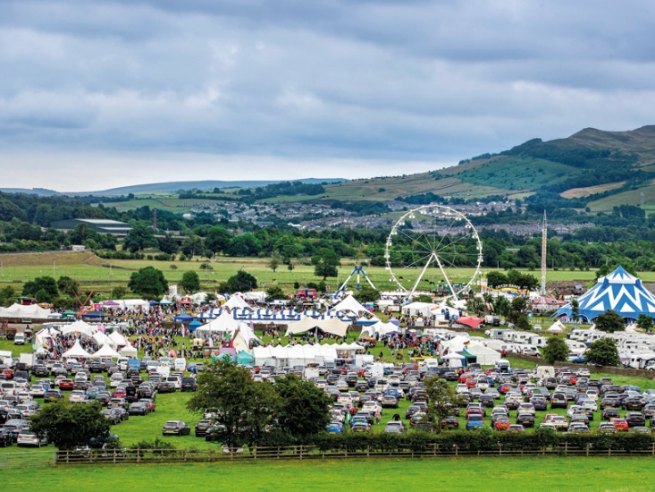 outdoor festival with tents and a Ferris wheel