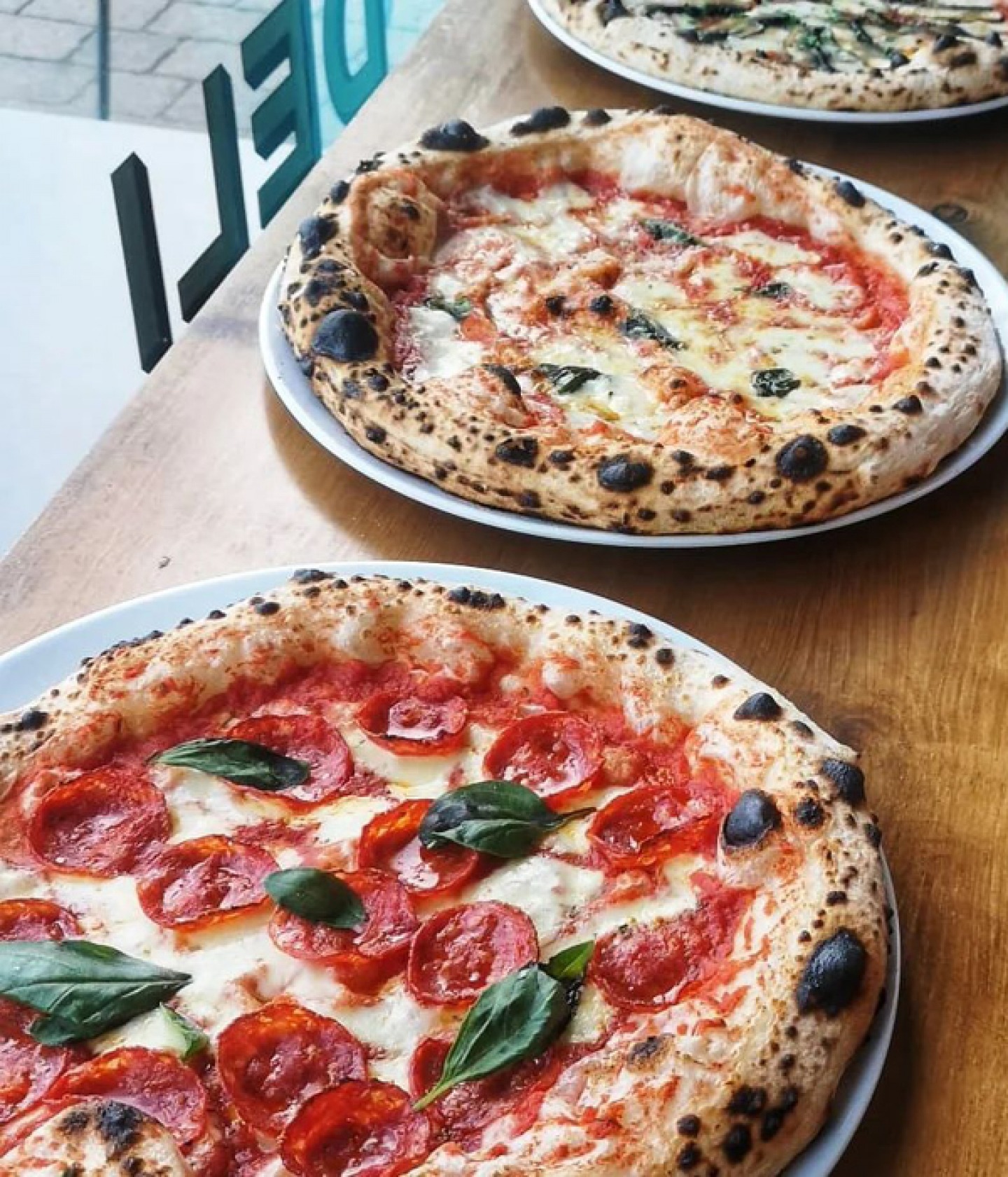 3 pizzas lined up at Up North Pizzeria & Deli