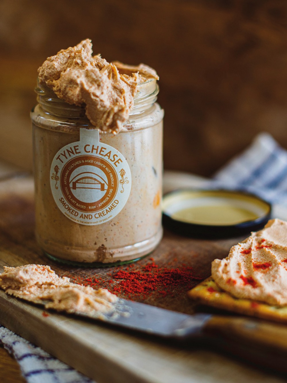 jar of vegan creamed cheese , with a knife and some spread on a cracker