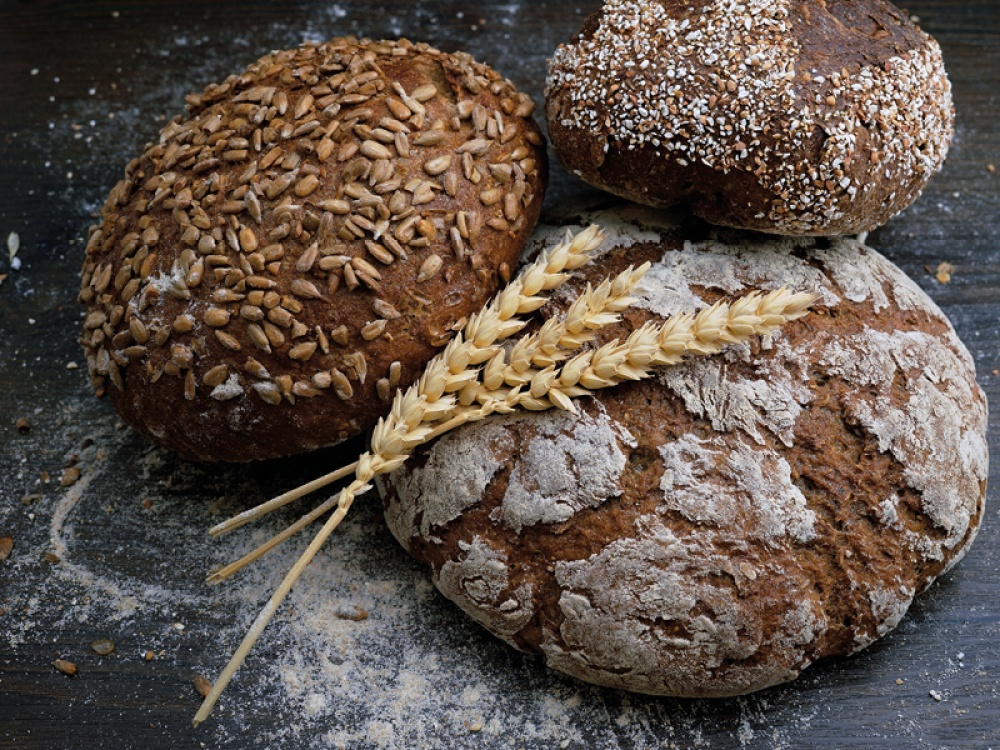 3 Cobs of bread with a stand of wheat