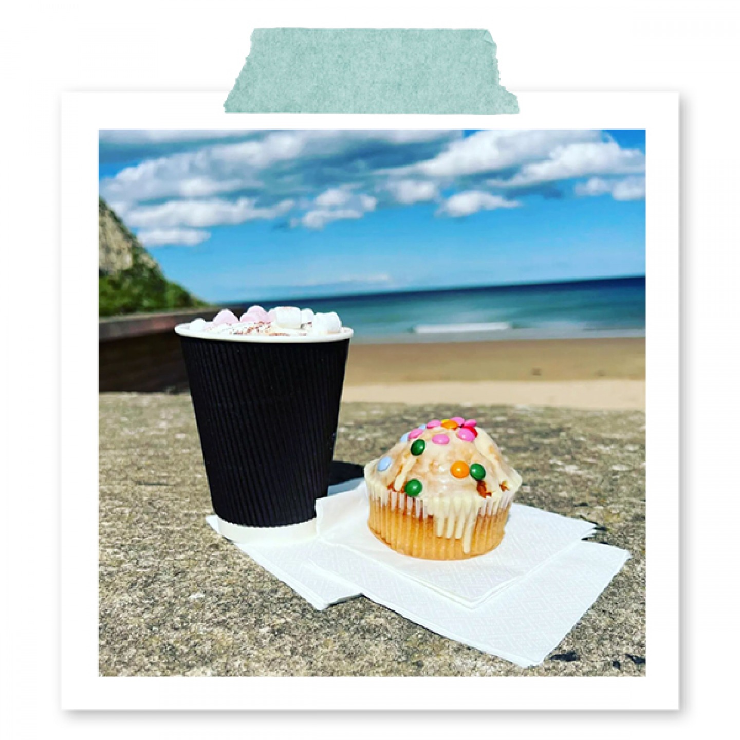 hot chocolate and a muffin with the beach in the background