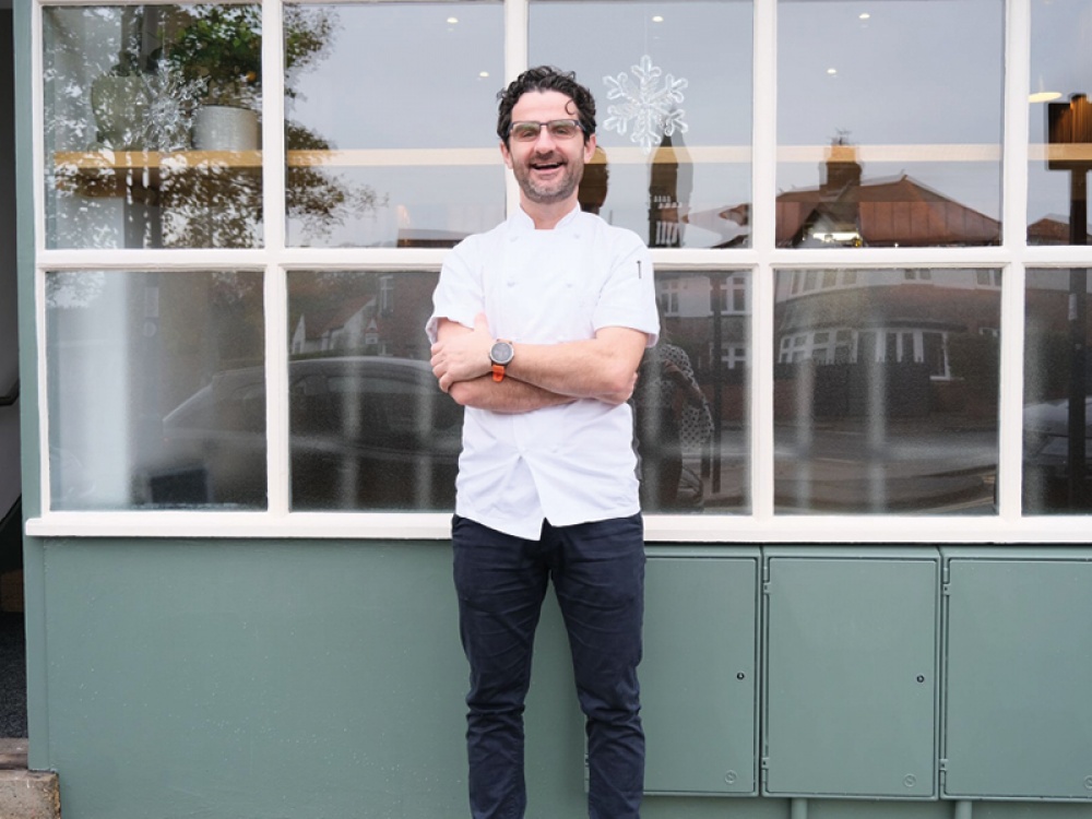 man smiling outside a restaurant