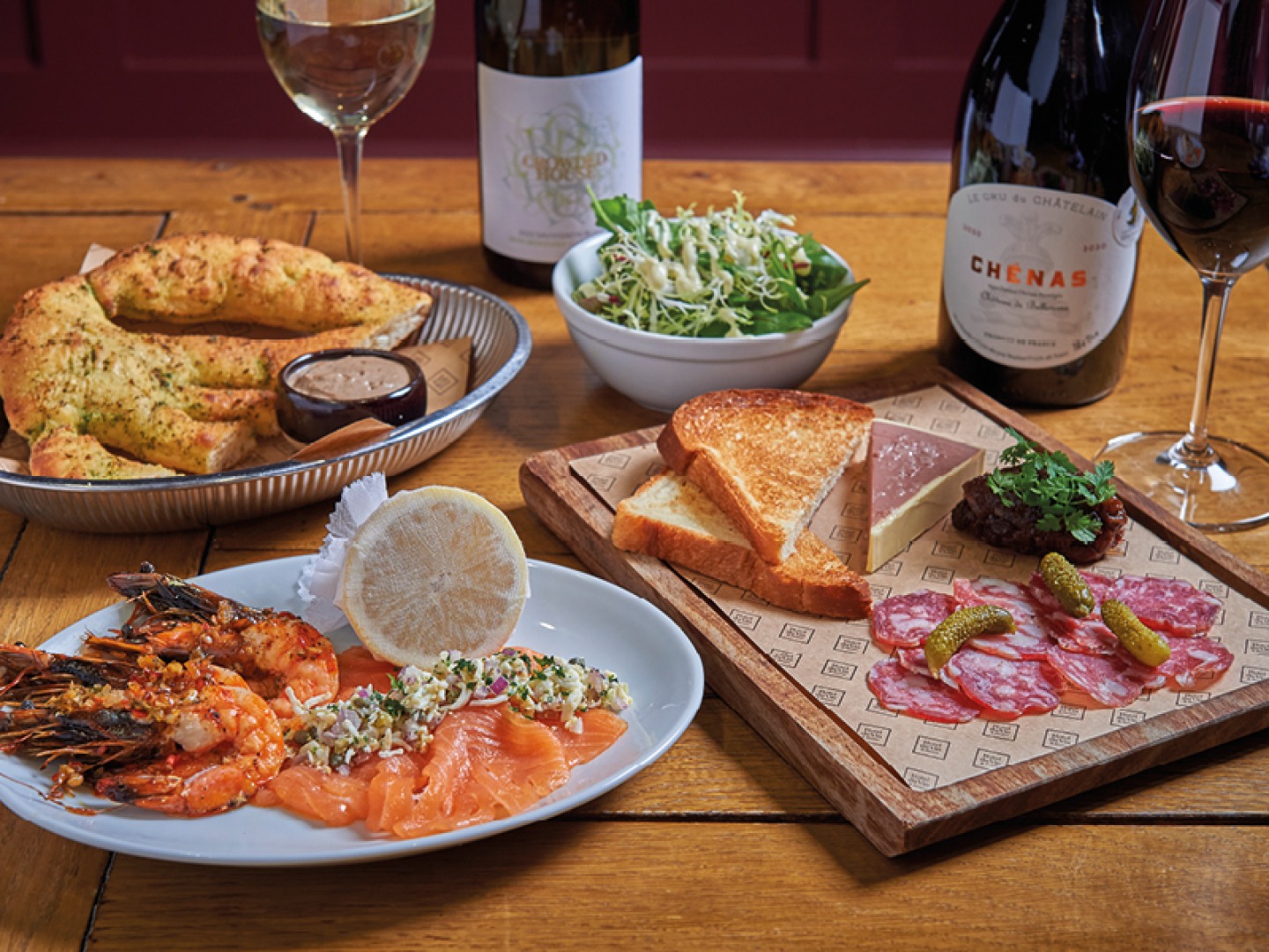 red and white wine with bread, a shellfish dish and a meat board