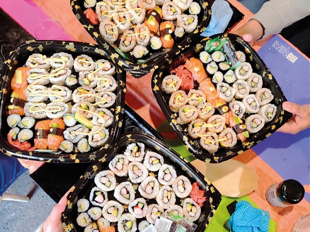 4 large black trays full of Sushi