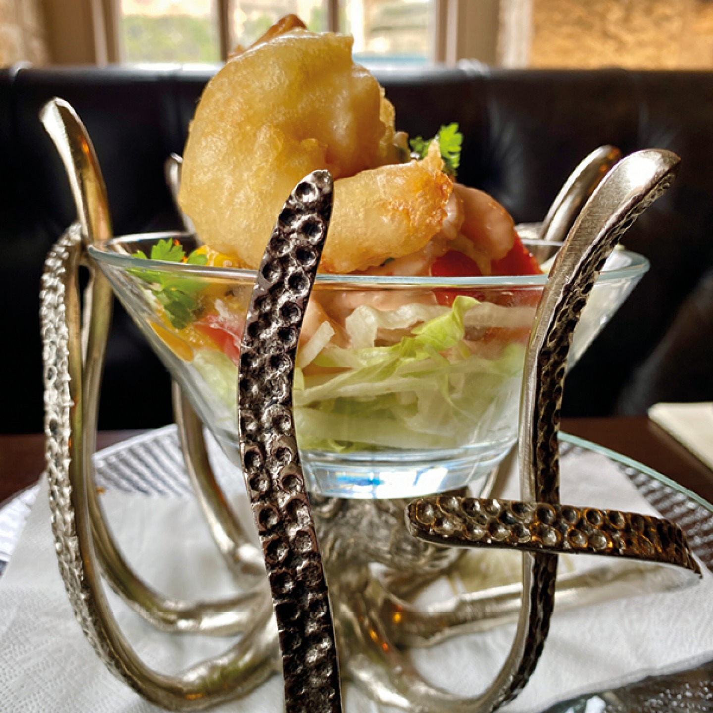 Prawn cocktail on a glass dish supported by metal tentacles