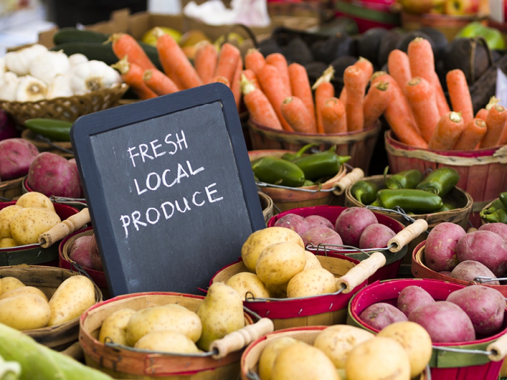 Fresh vegetables in buckets with 'Fresh Local Produce' sign