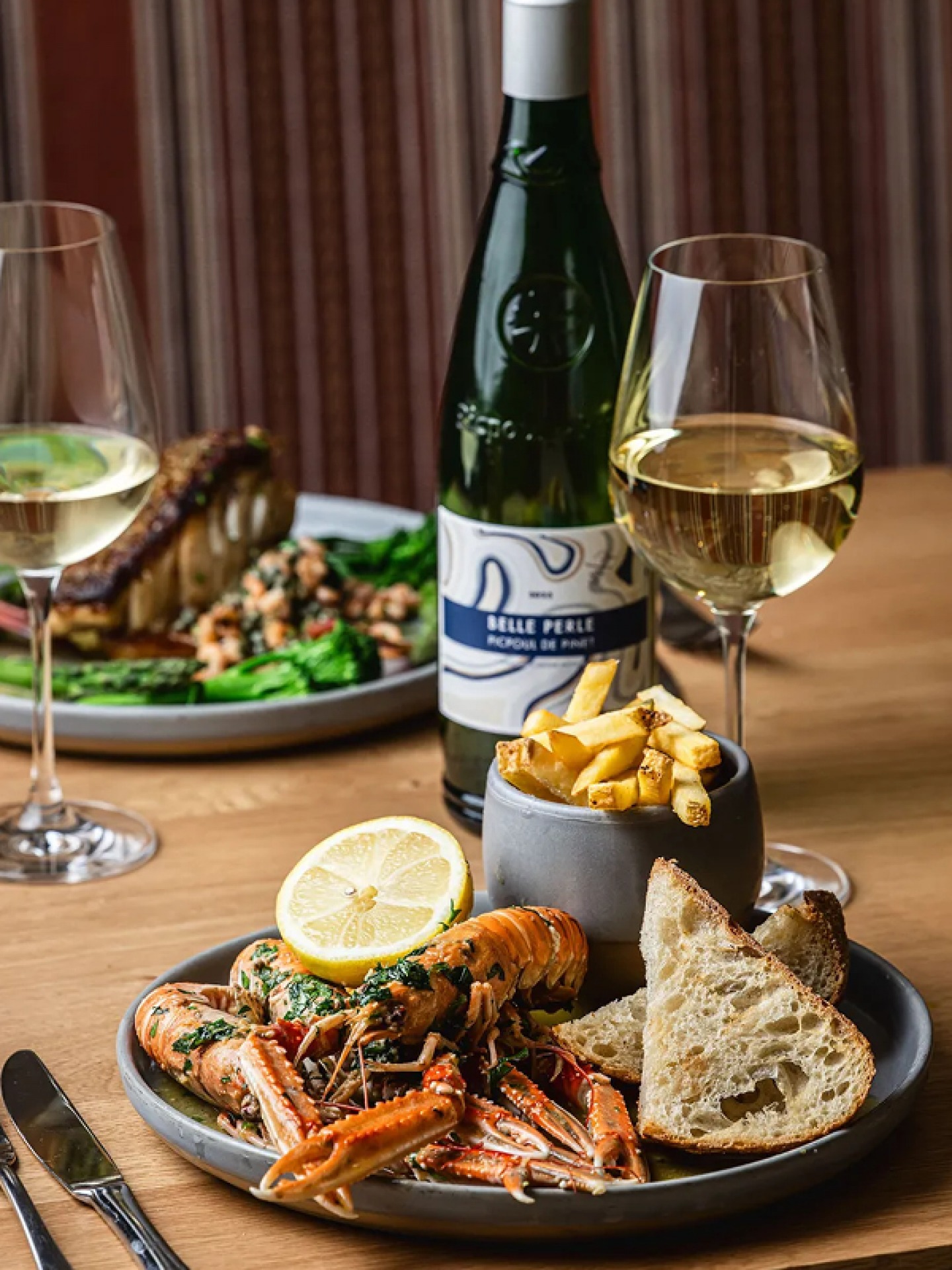 langoustines with a pot of fries, bread, lemon and a glass of white wine