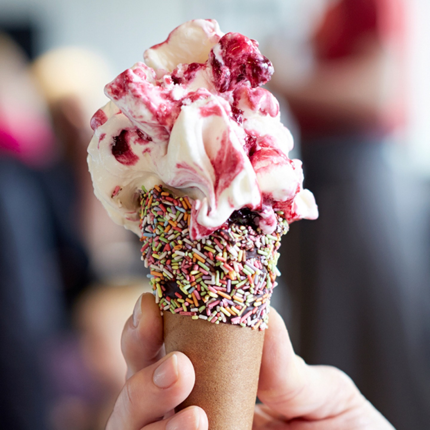 Sprinkle ice cream cone with vanilla and raspberry ice cream
