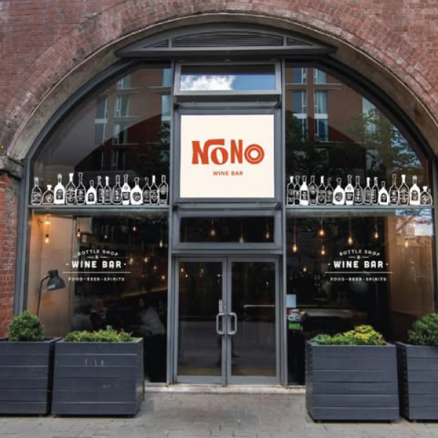 Nono wine shop front. Large floor to ceiling arched glass window and door