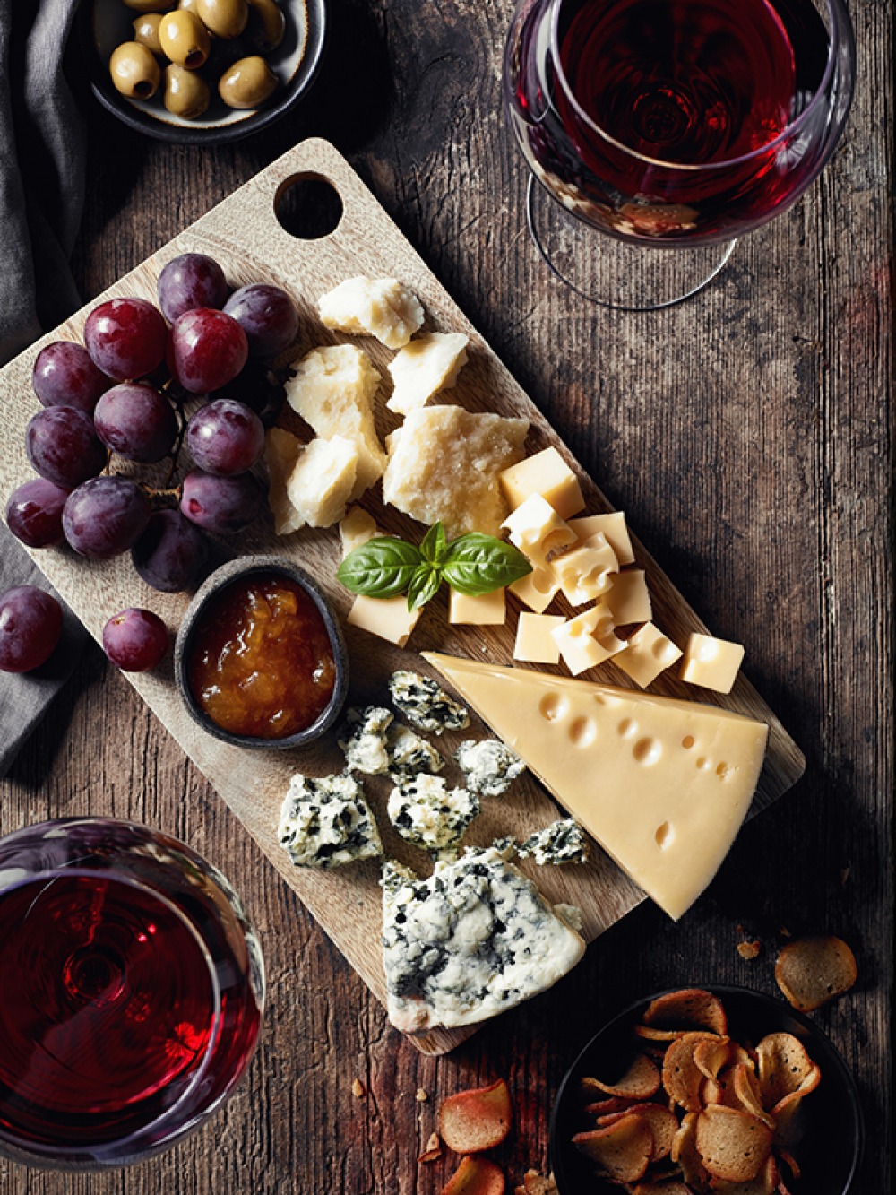 Cheese board with wine, olives and chutney