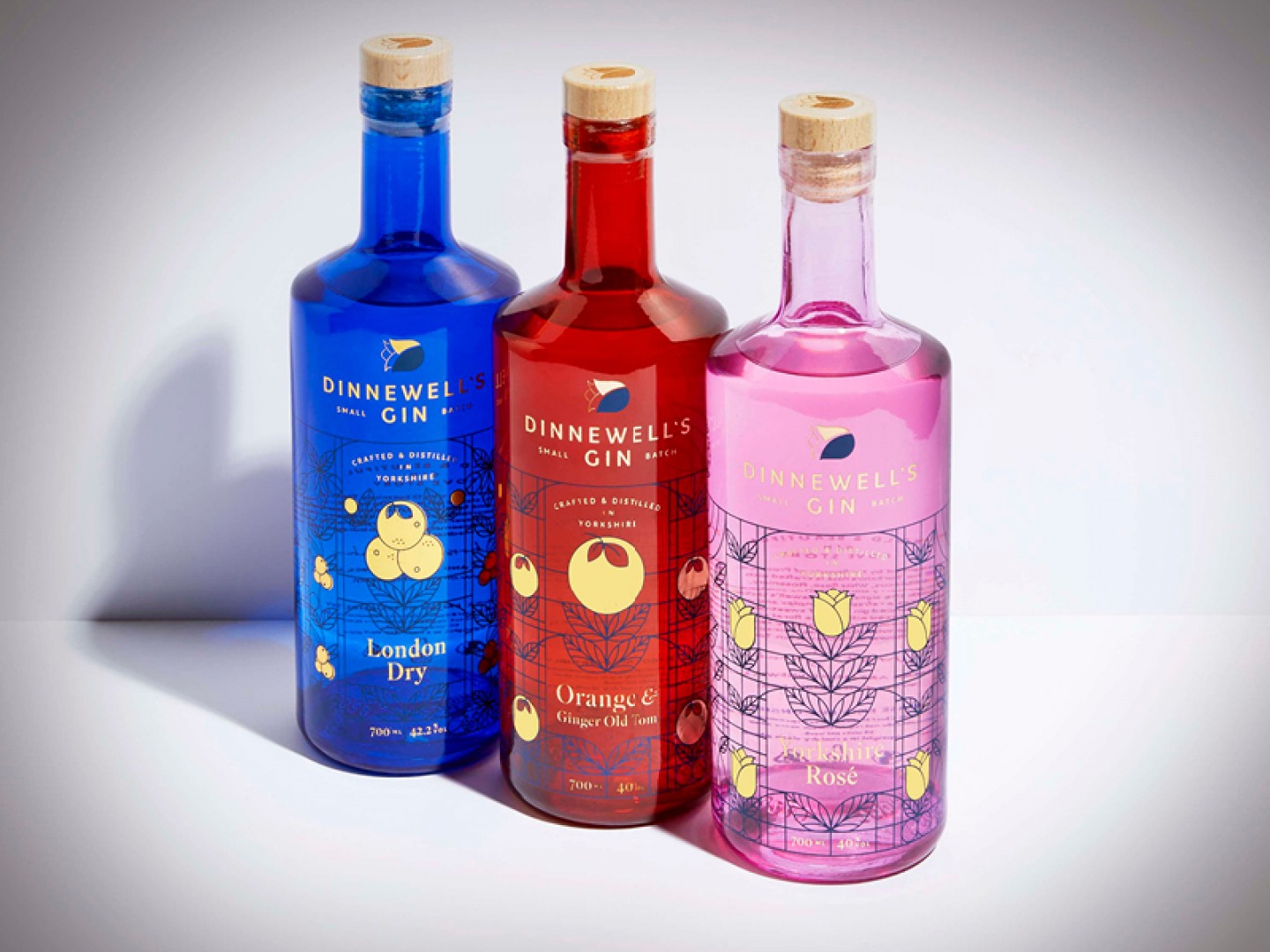 3 bottles of gin, one blue, one pink, one red