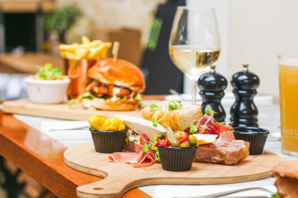 Burger and chips and charcuterie board with wine and beer