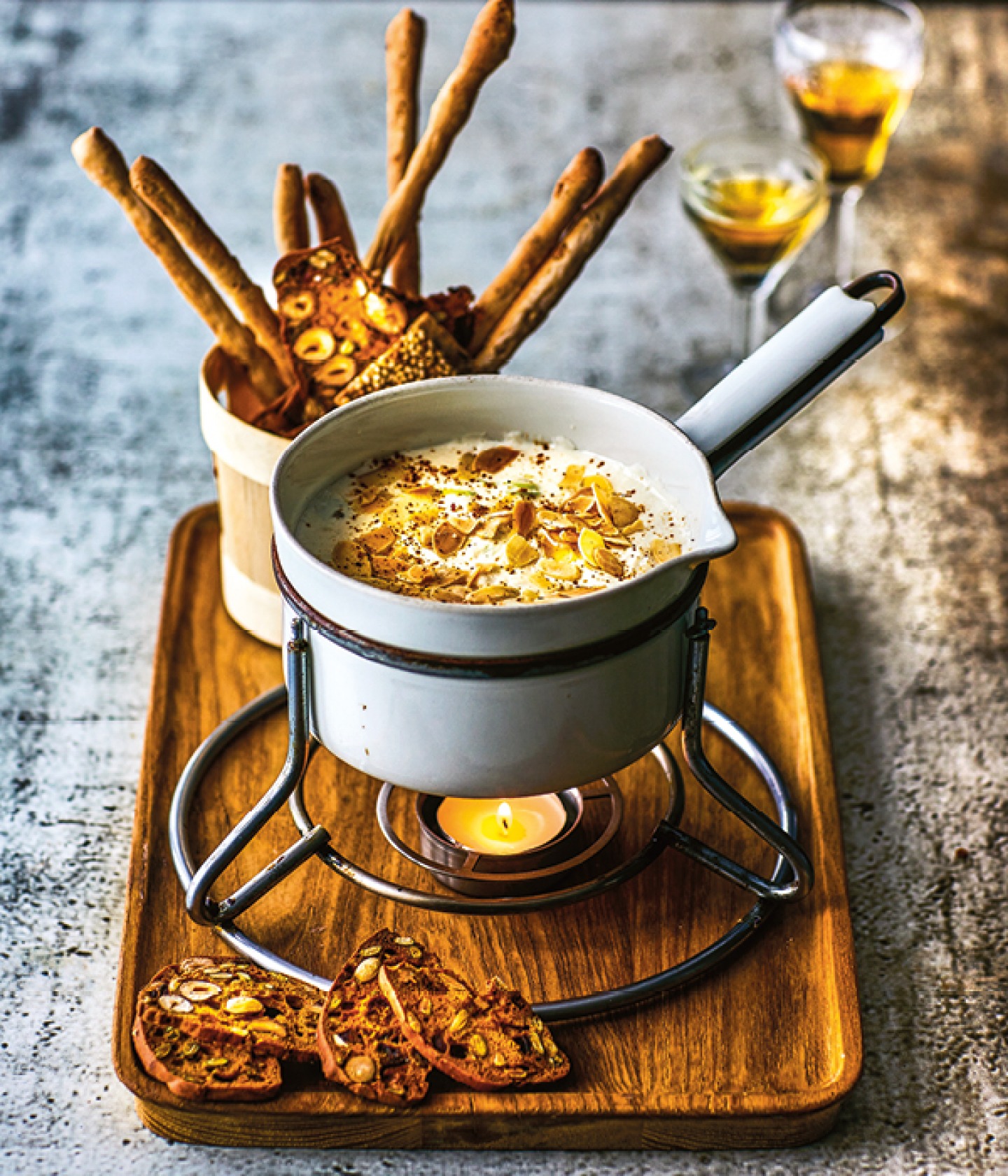 fondue with nuts on top and breadsticks