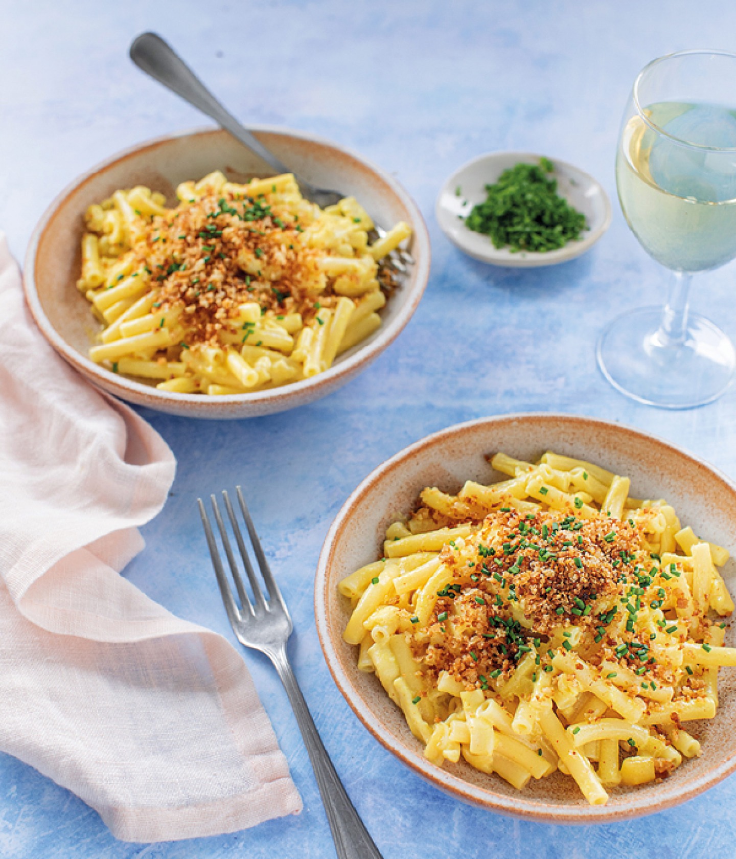 a blue table with a bowl of Mac and cheese