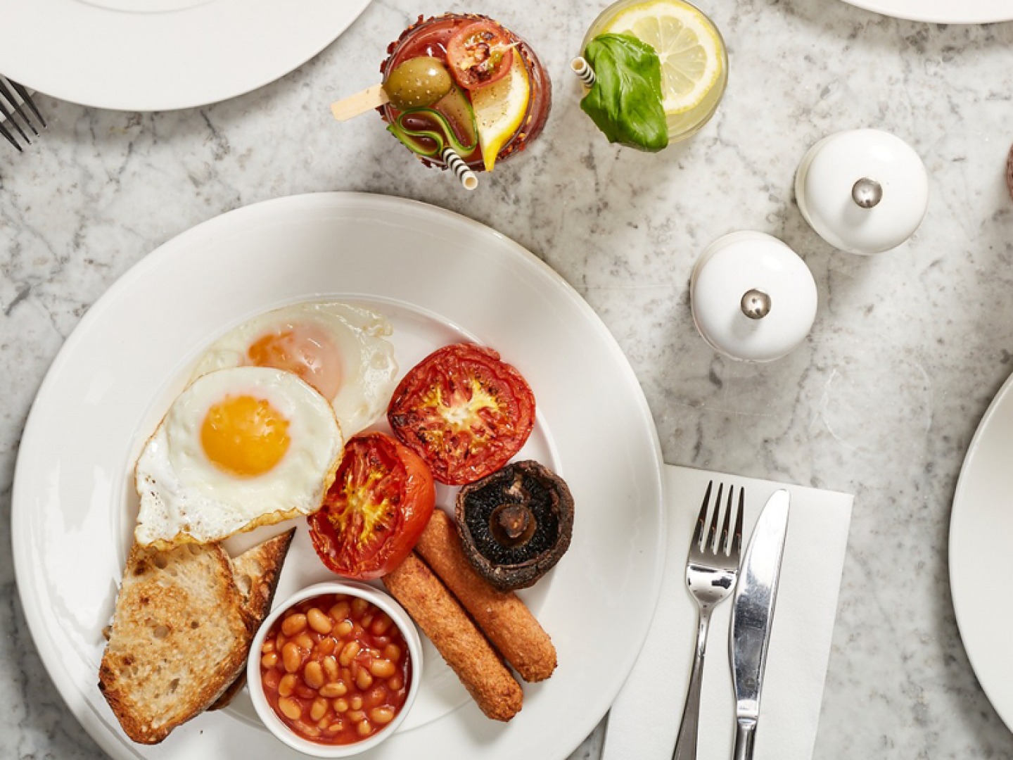 looking down on a full plate of breakfast food with cocktails