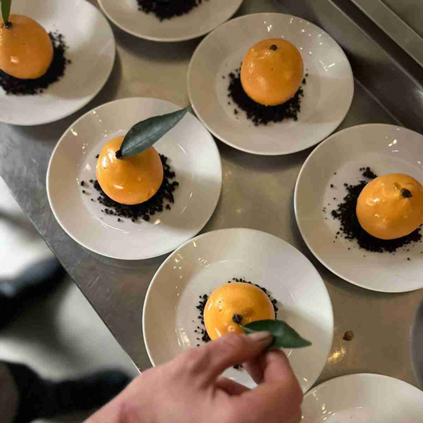Orange desserts on a crumb base topped with a leaf