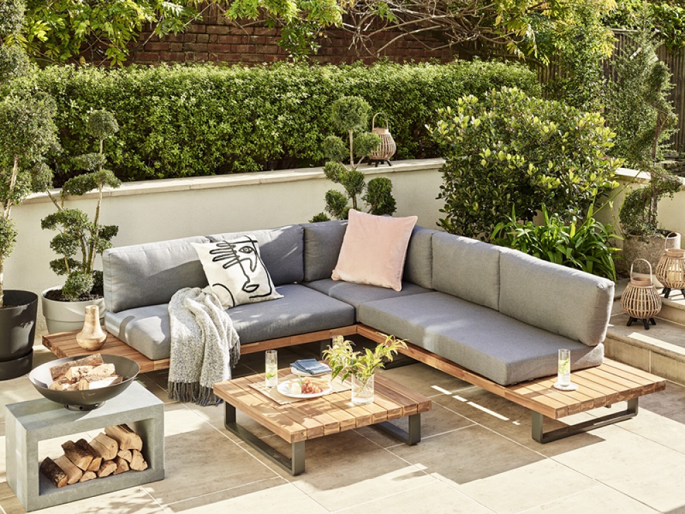 outdoor L shaped sofa on a patio surrounded by plants