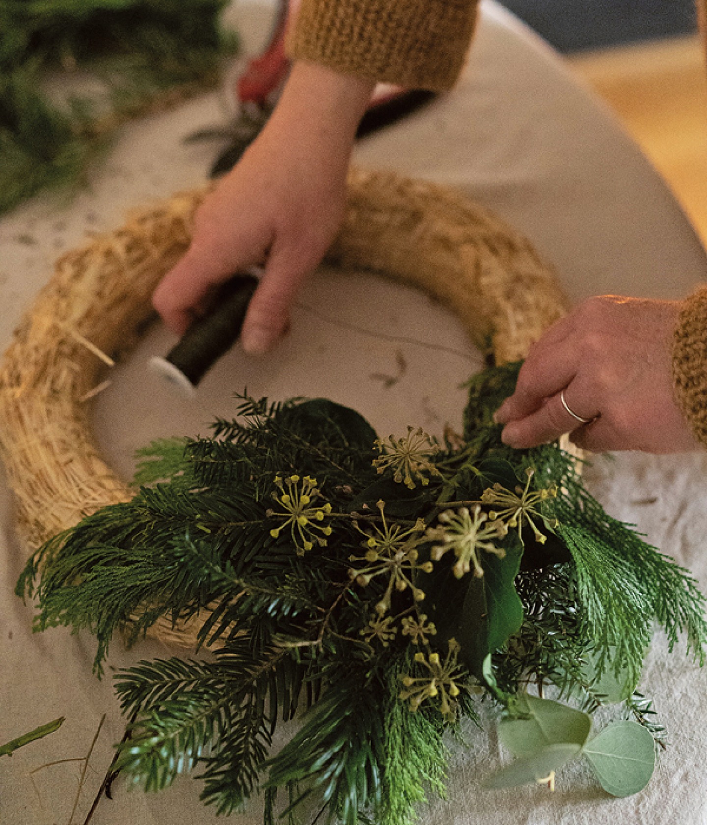 foliage being attached to hoop with florist wire