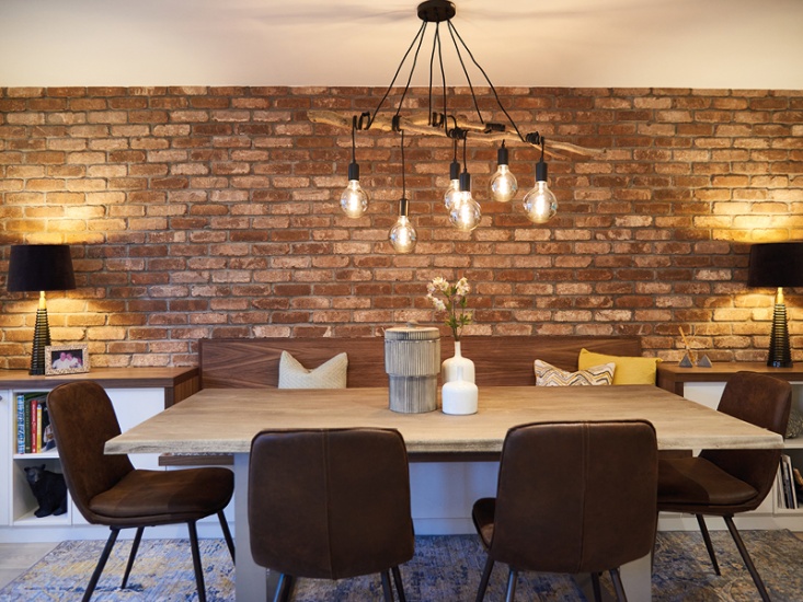 Dining table with brick wall and hanging lights