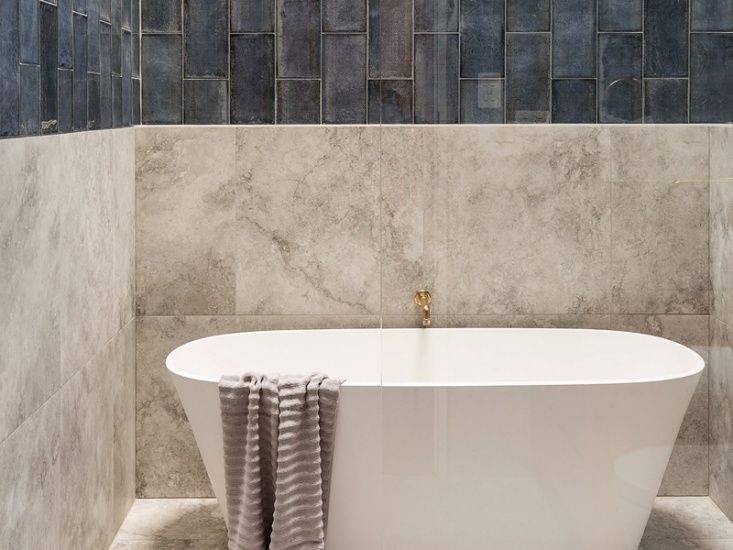 Free standing bath in modern tiled bathroom