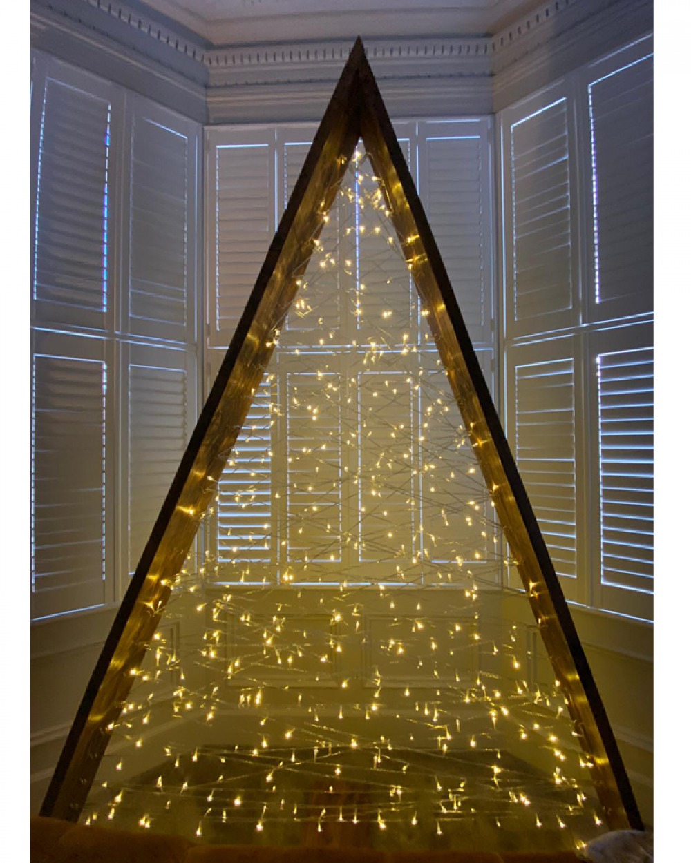Wooden triangle with lights strung inside