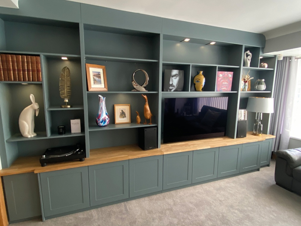 floor to ceiling blue shelves with TV and art on the shelves