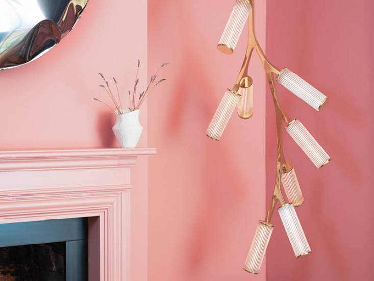 Modern, abstract lighting hanging in the corner of a pink painted room
