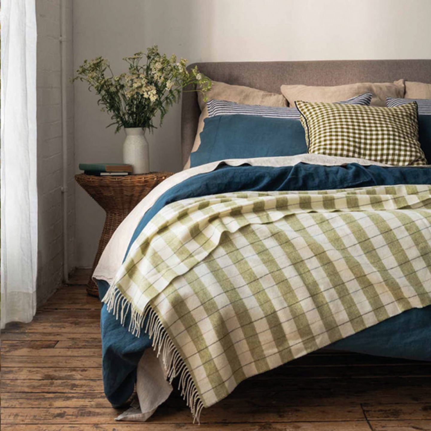 Apple checked stripe wool blanket draped over a styled bed