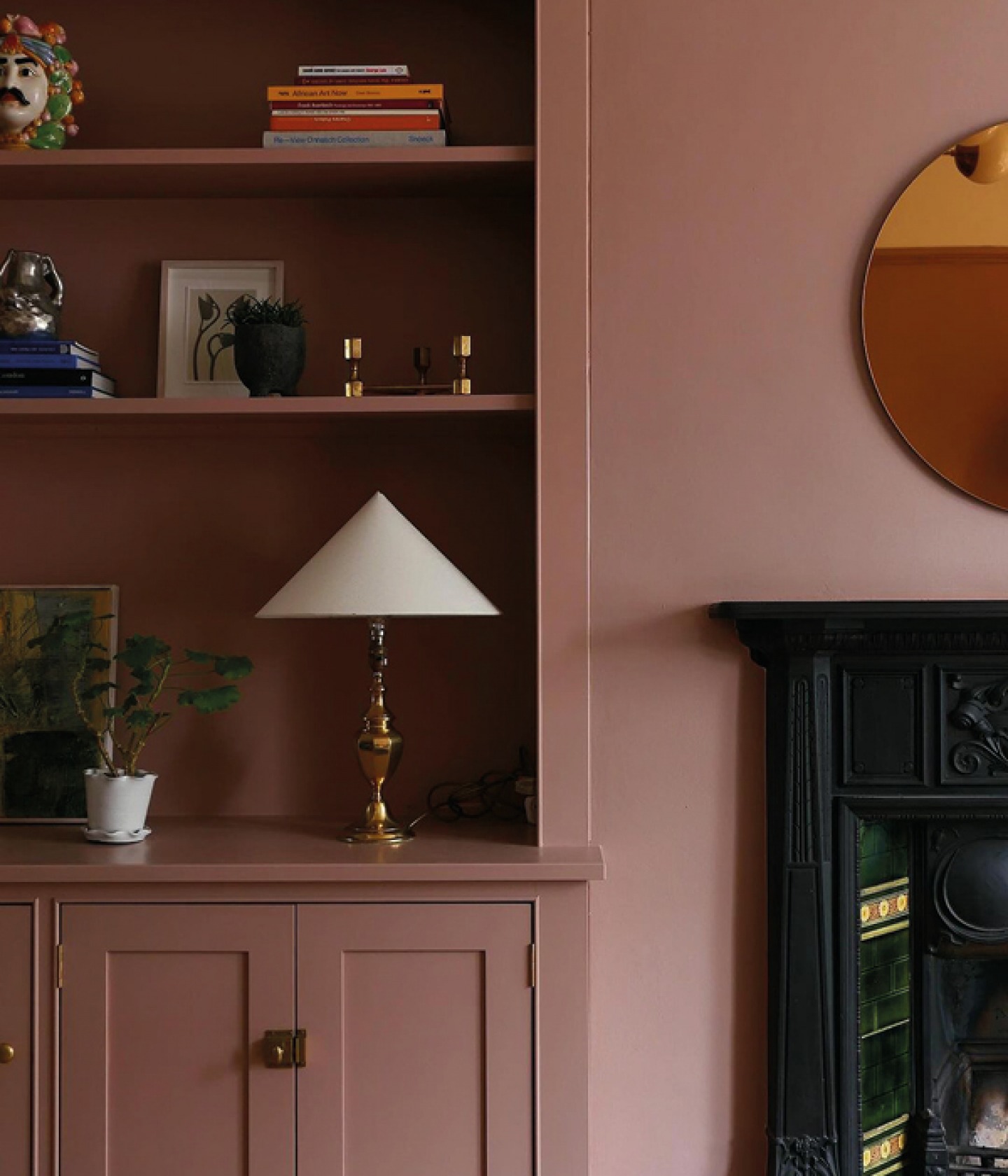 Wall and Shelving colour drenched in dusky pink with period black fireplace