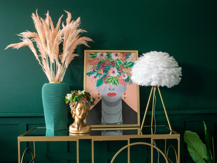 side table set with feathered lamp, pampas grass, floral portrait and ornament