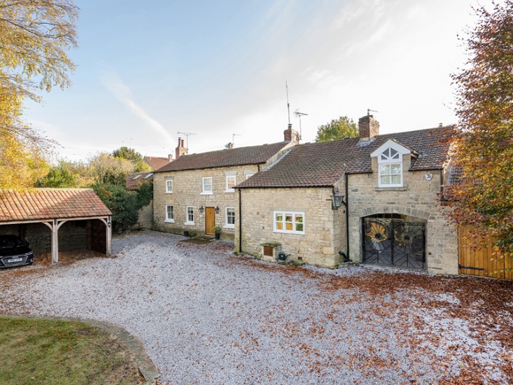 stone house with large gravel driveway