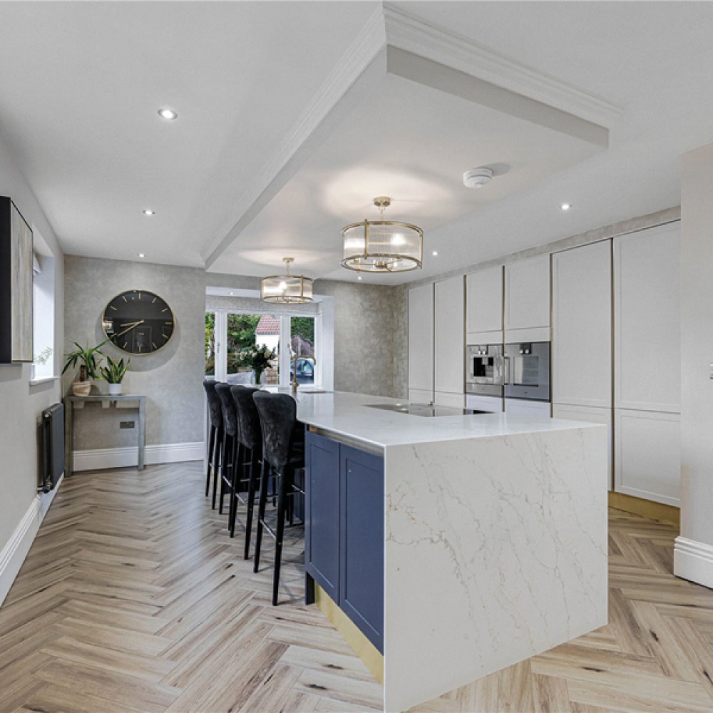 white marble kitchen with navy blue cupboards