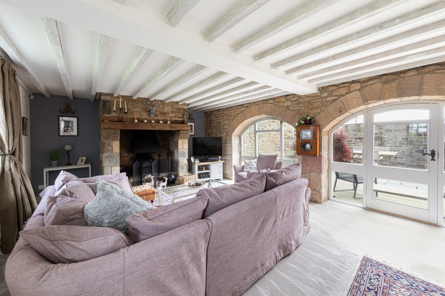 lounge with large open fireplace and exposed stone wall