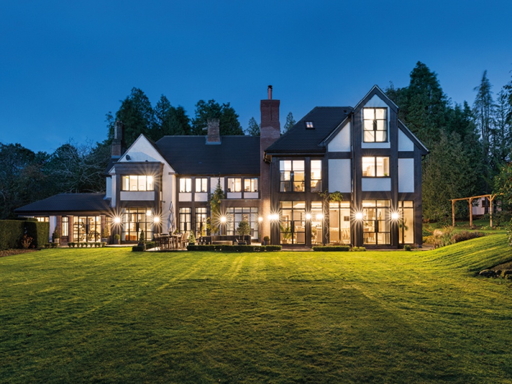 large house with large windows at night time lit up