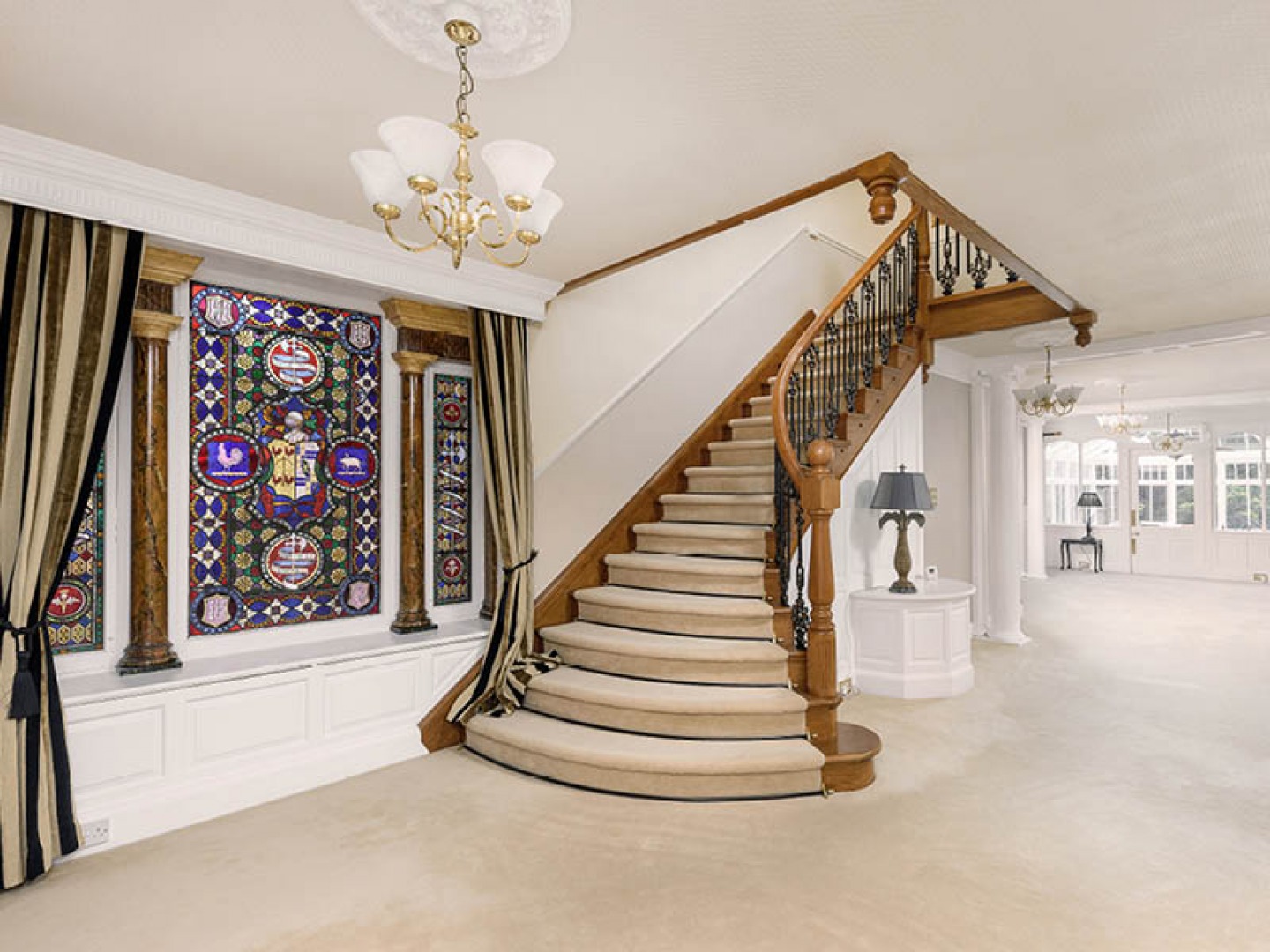 large staircase with stained glassed windows at the bottom