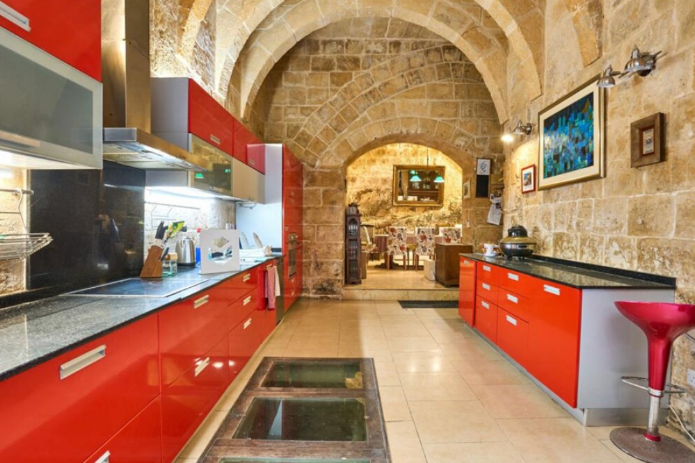 Modern high gloss red kitchen in a Traditional stone building with barrel-vaulted ceiling