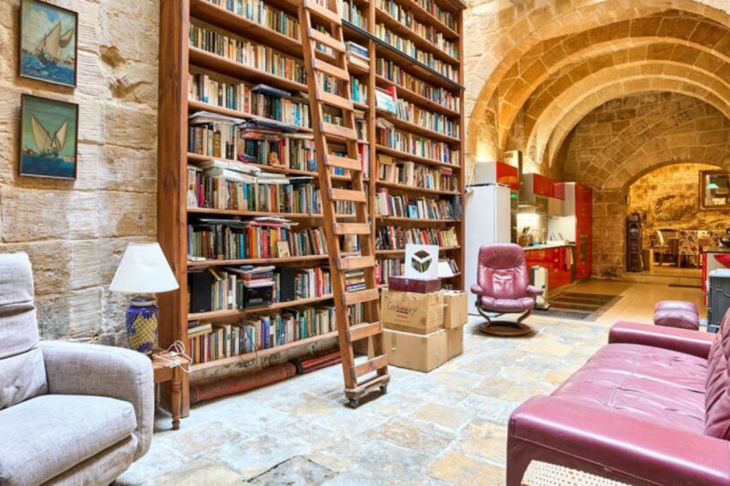 Exposed stone walls with floor to ceiling bookshelf and comfy seating