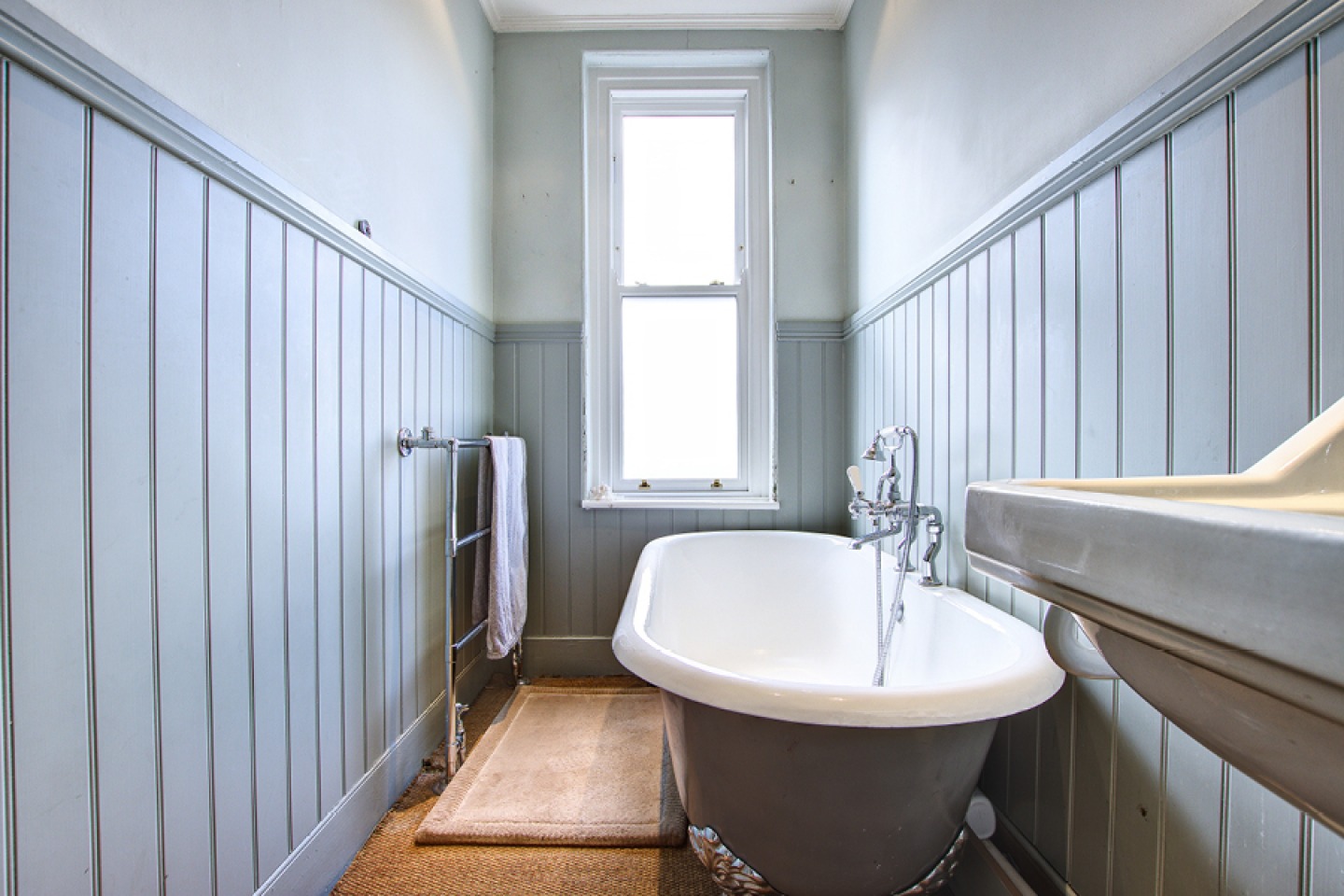 wood panelled bathroom with free standing bath