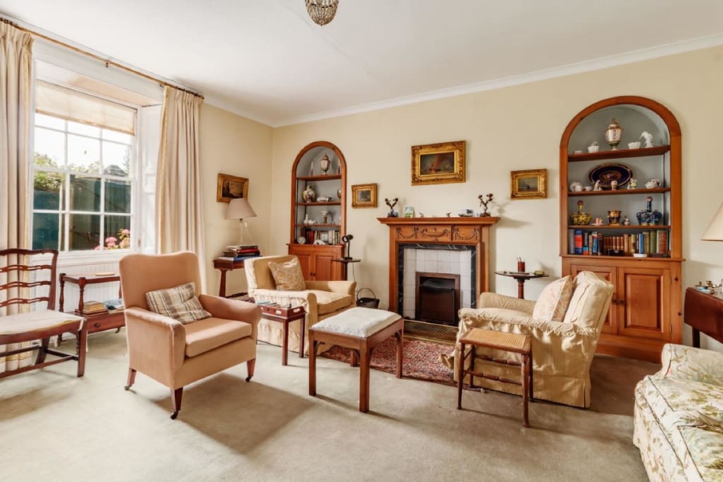 period lounge with alcove shelving and feature fireplace