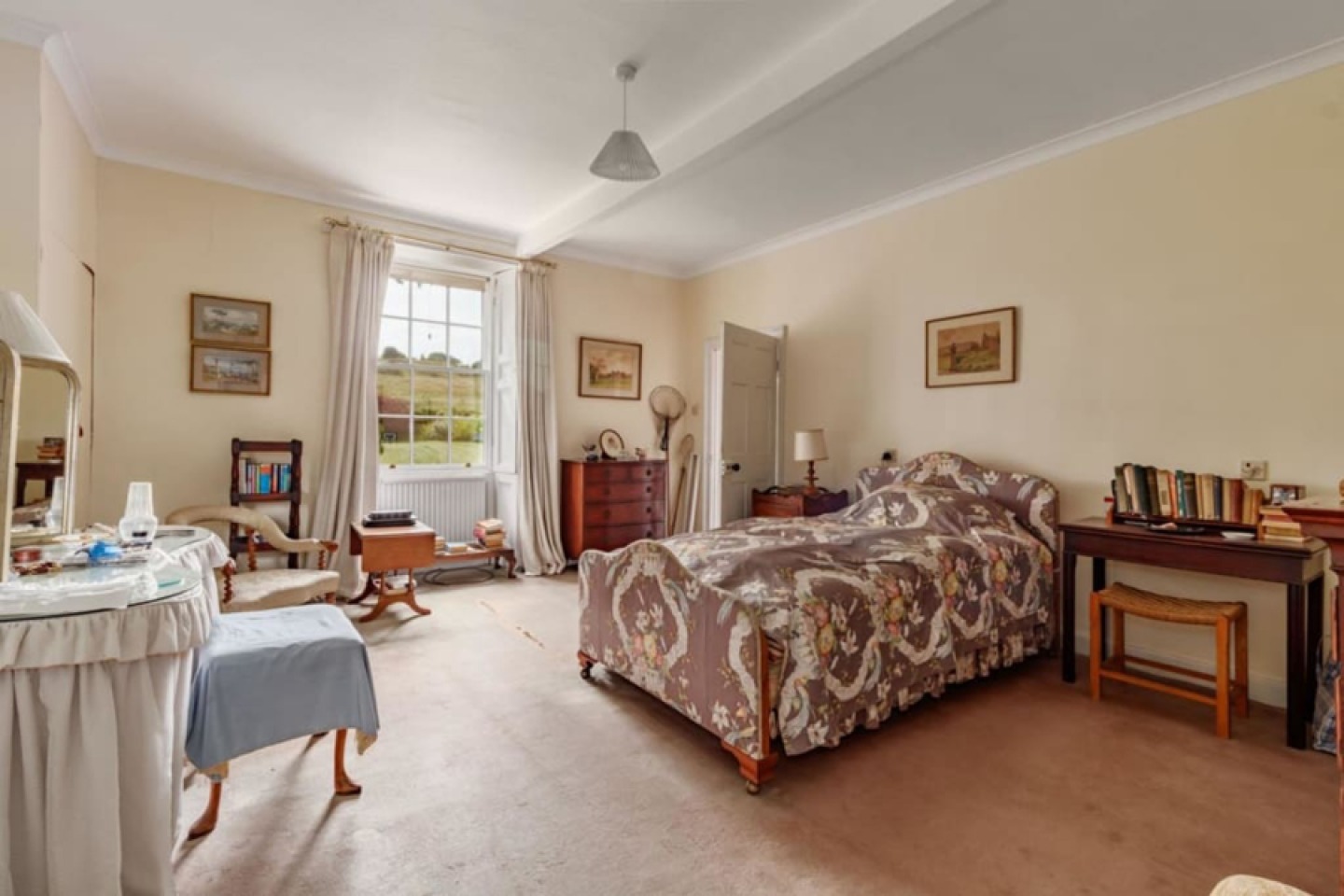 Neutral bedroom with large window and views over countryside