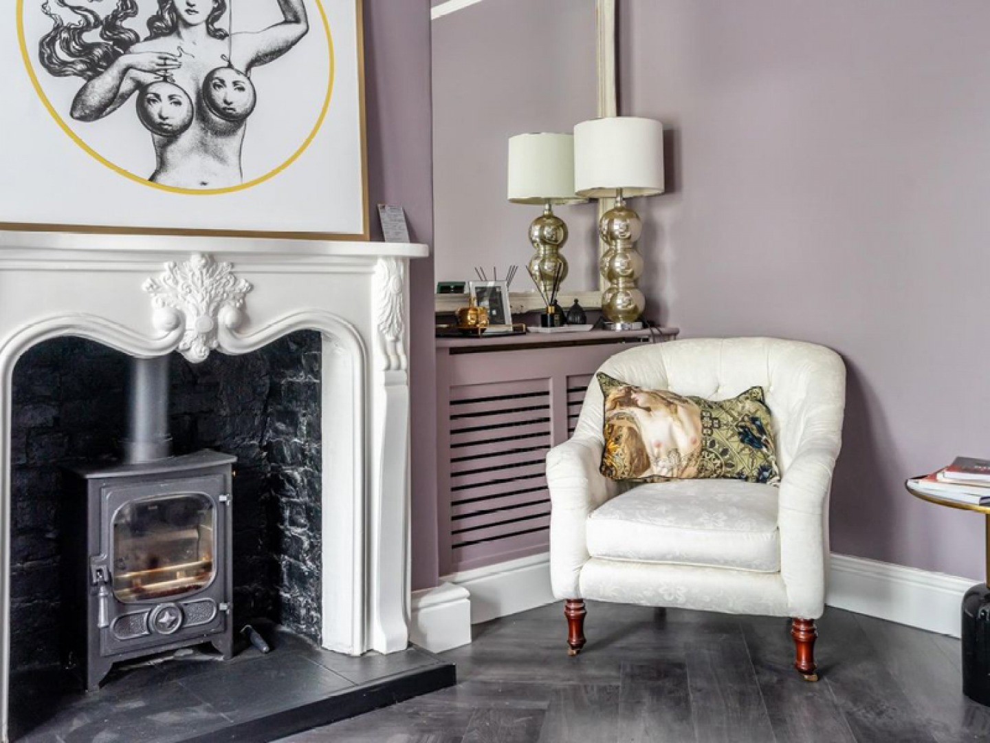 traditional fire place with modern art and armchair