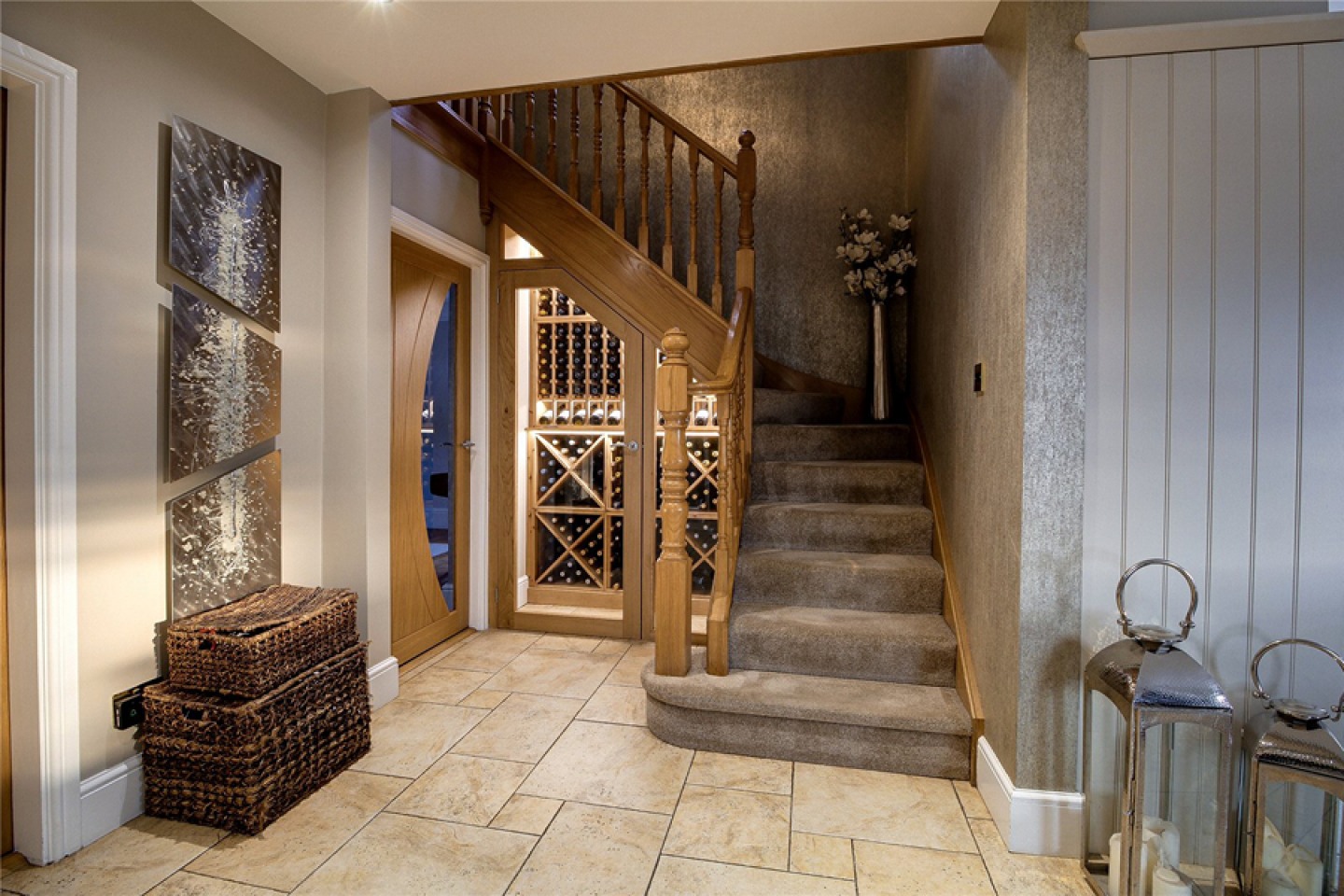Built-in glass fronted wine storage under staircase
