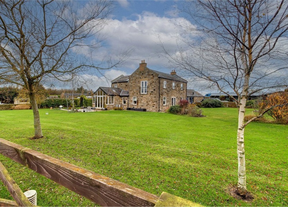 free-standing stone farmhouse surrounded by lawned garden
