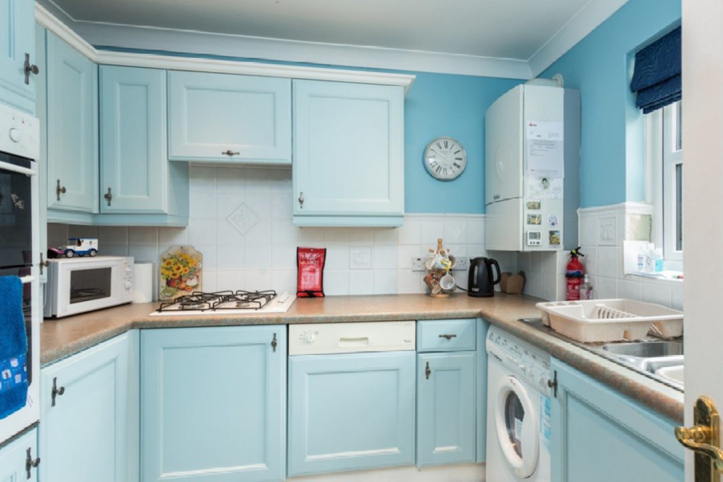 Small square kitchen with light blue cabinets and blue walls