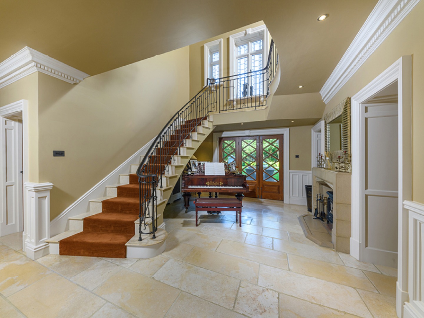 Curved marble staircase leading up to the galleried landing above