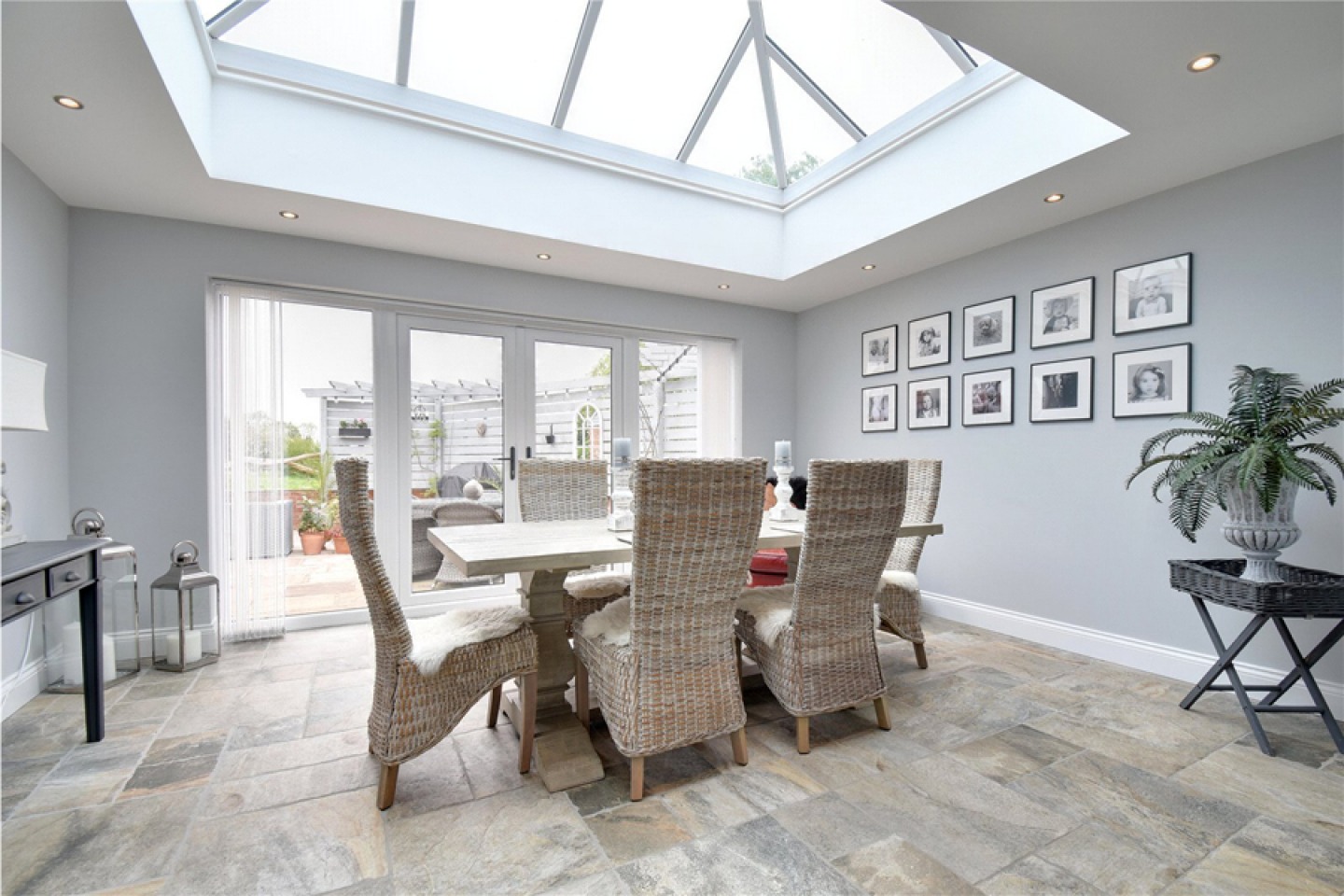 Dining room with patio doors, grey decor and roof lantern